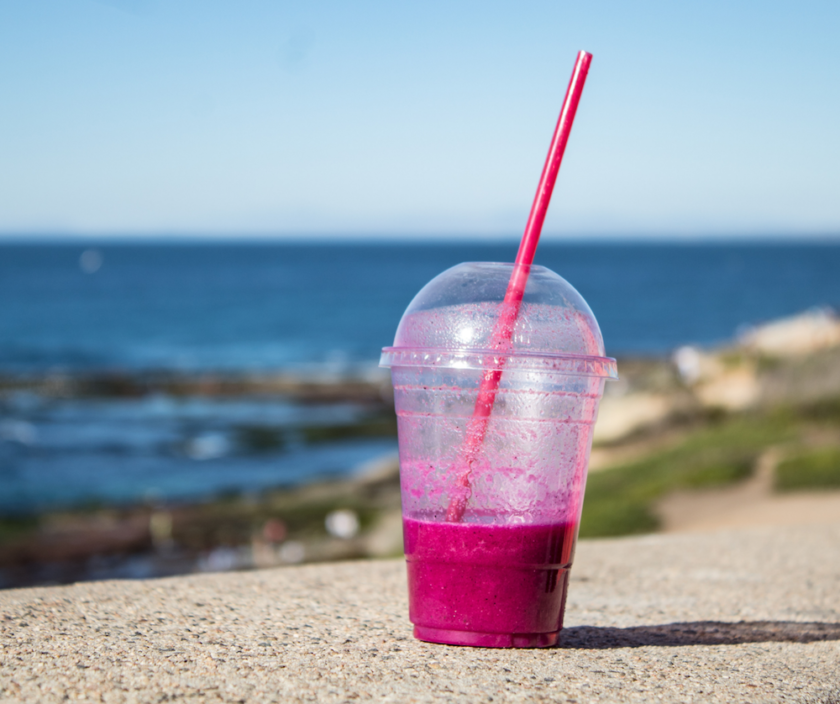 Plasticsugerør i et plastbæger på en strand. Mandagstip fra Bagvrk.dk.