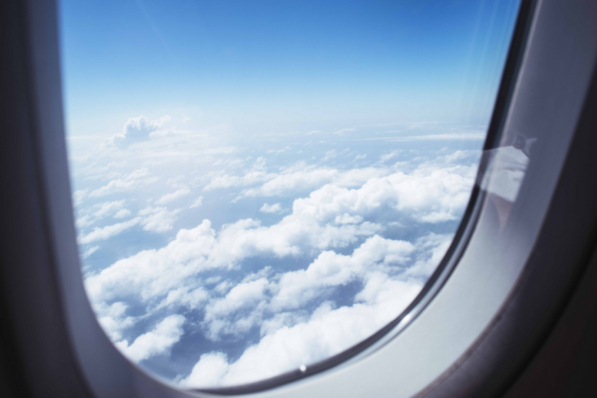 Skyer udenfor flyvindue Flyforsinkelse